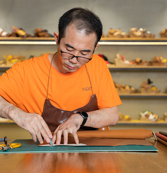 A worker cut the leather for the upper by hand.