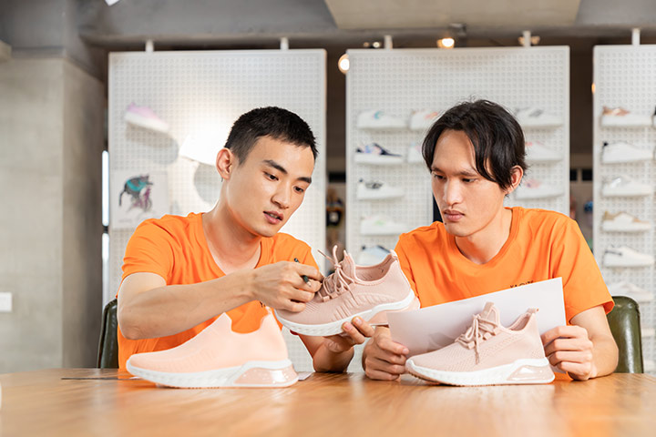 Two designers are discussing shoe samples and designs.