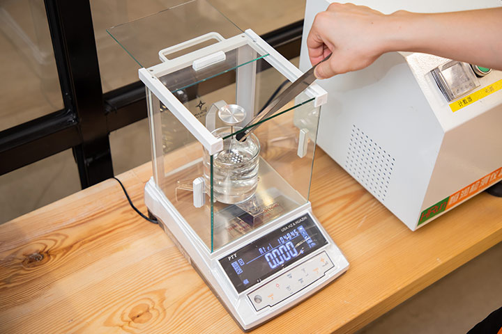 An employee uses an instrument to test the density of the sole material.