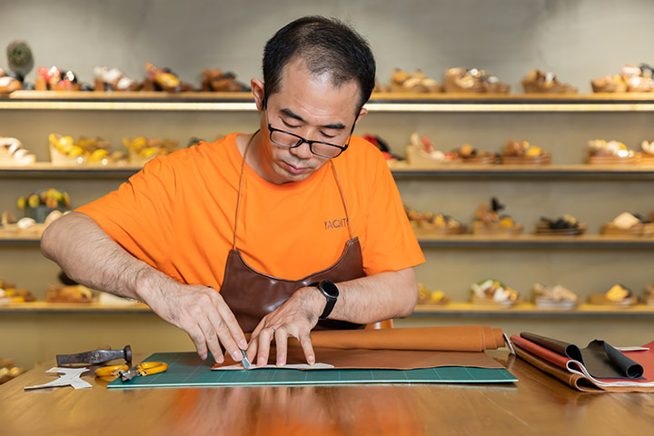 A worker cut the leather for the upper by hand.