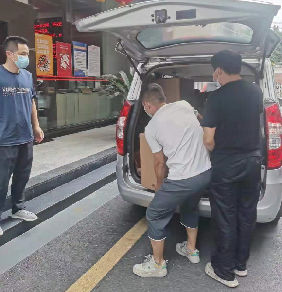 Two employees are unloading the goods from the car.