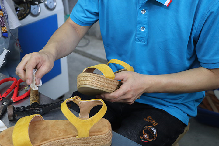 A worker wipes the stains brought by the production process on the surface of shoes to make them more beautiful.